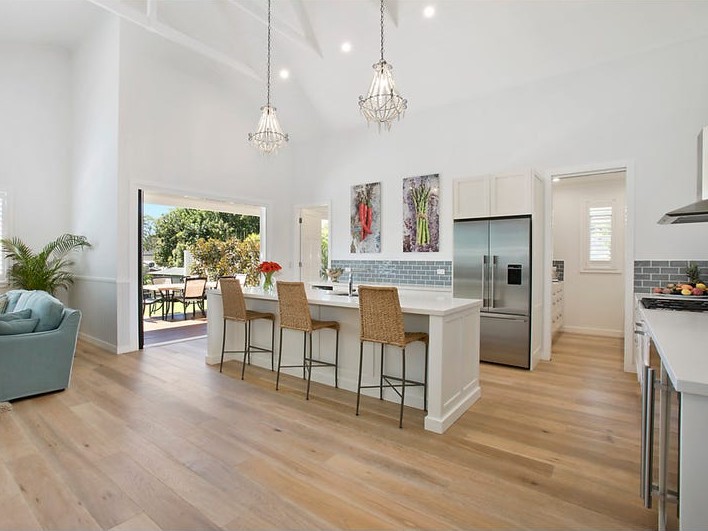Modern open plan kitchen with island bench and timber floorboards